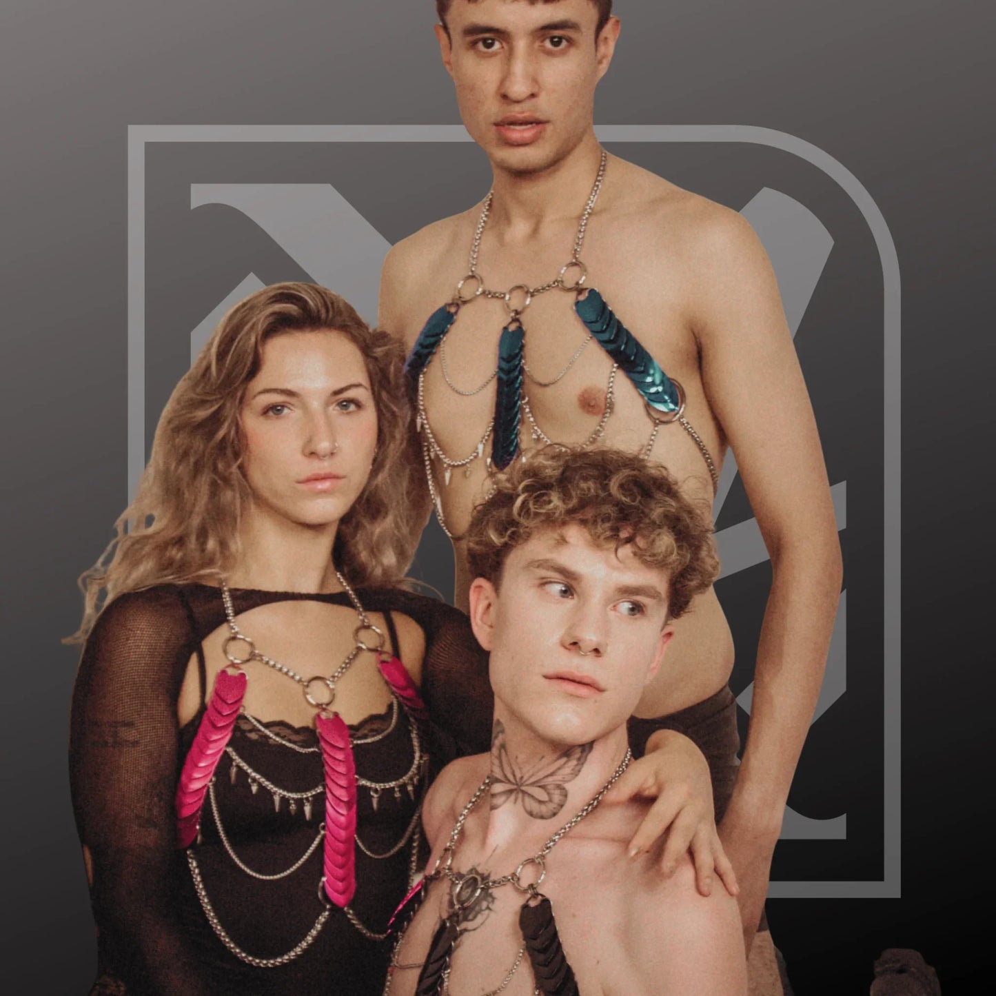 Drei Personen tragen handgefertigte Scalemail Bodychains und Harnesses aus Silberketten mit auffälligen pinken, blauen und schwarzen Schuppen, modern und künstlerisch, ausdrucksstarkes, selbstbewusstes Styling.