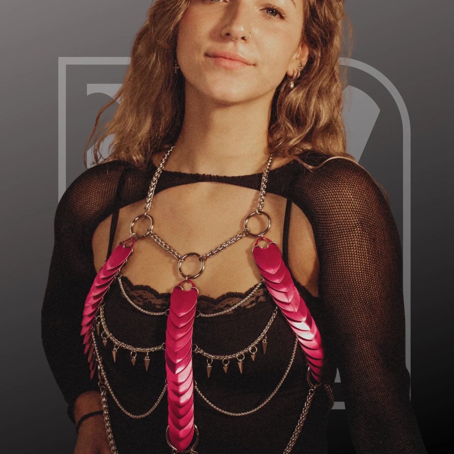Silberner Harness mit pinken Scalemail-Ketten, auffälliger Bodychain-Stil, selbstbewusst