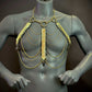Goldener Aphrodite Fire Harness mit Ketten und Plättchen auf grauem Männer-Mannequin, elegant und kraftvoll