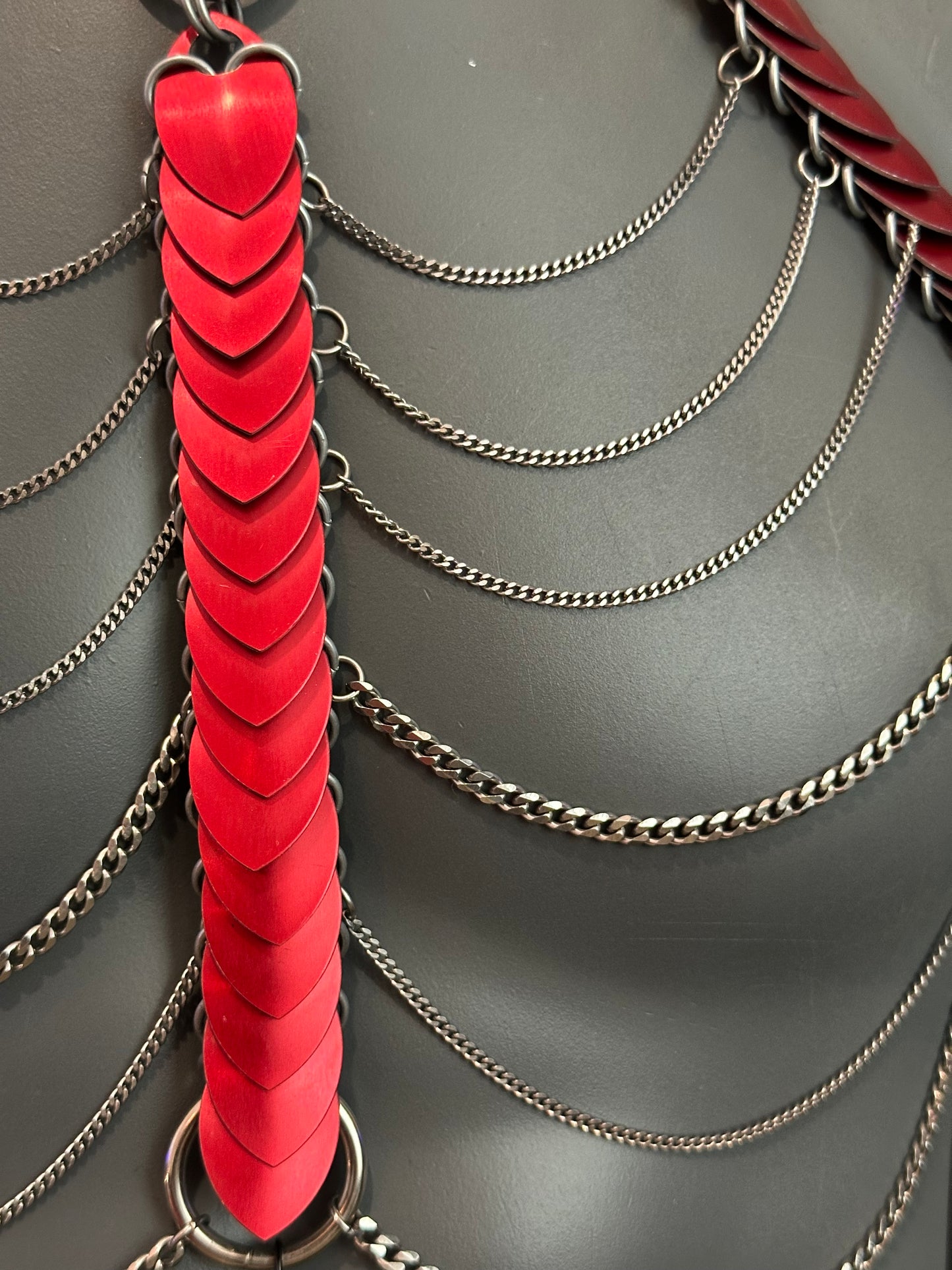 Feuerrotes Kettenharness mit roten Schuppen und silbernen Ketten, kraftvoll und leidenschaftlich
