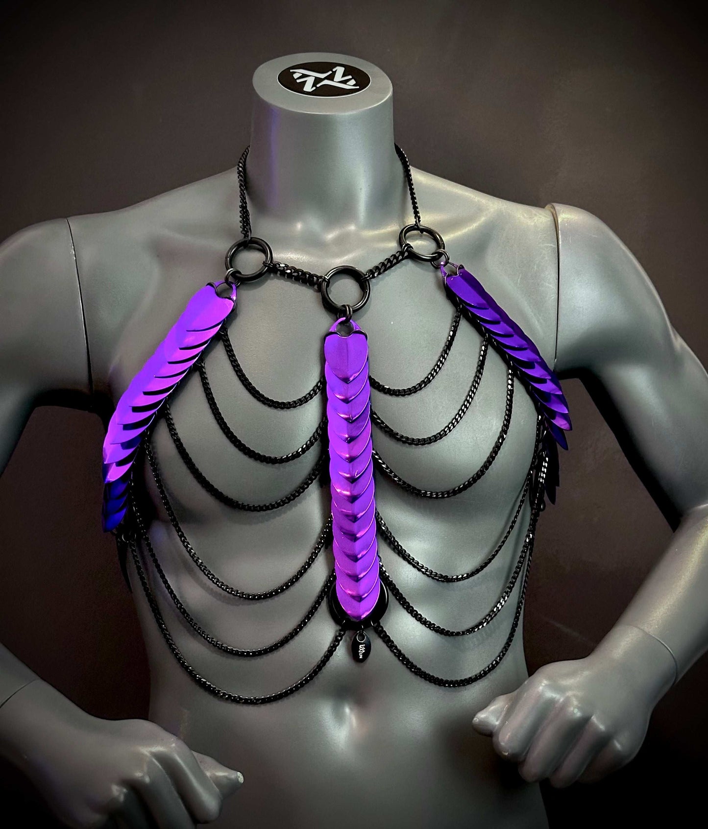 Körperkette aus schwarzen Ketten mit reflektierenden violetten Elementen, futuristisch, kraftvoll