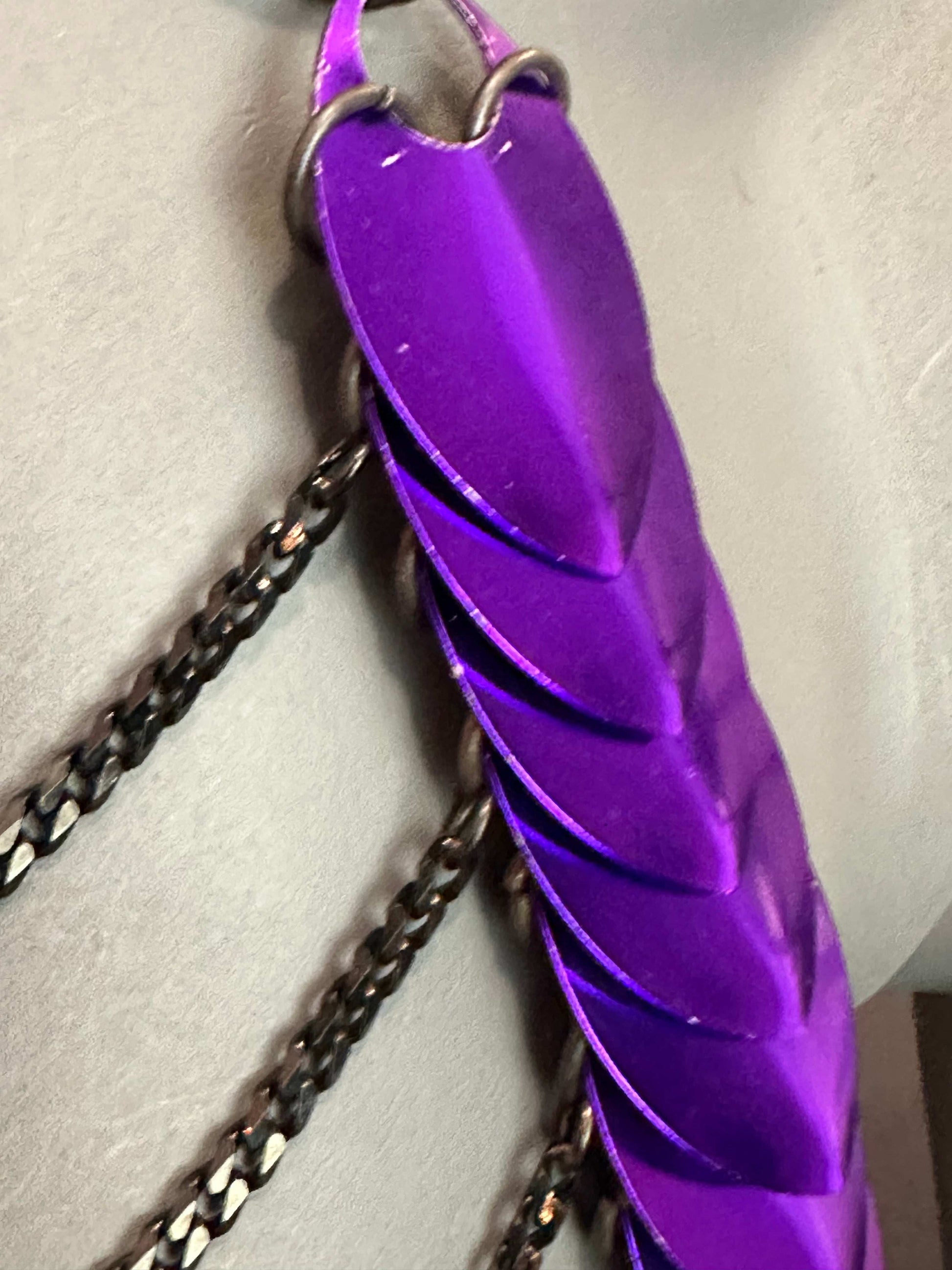 Ledertasche in violett mit silbernen Kettenriemen, modern und elegant, strahlt Leidenschaft aus