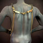Ariv Harness Gold, Rückenansicht mit goldfarbenen Ketten und glänzenden Plättchen, elegant und stylish