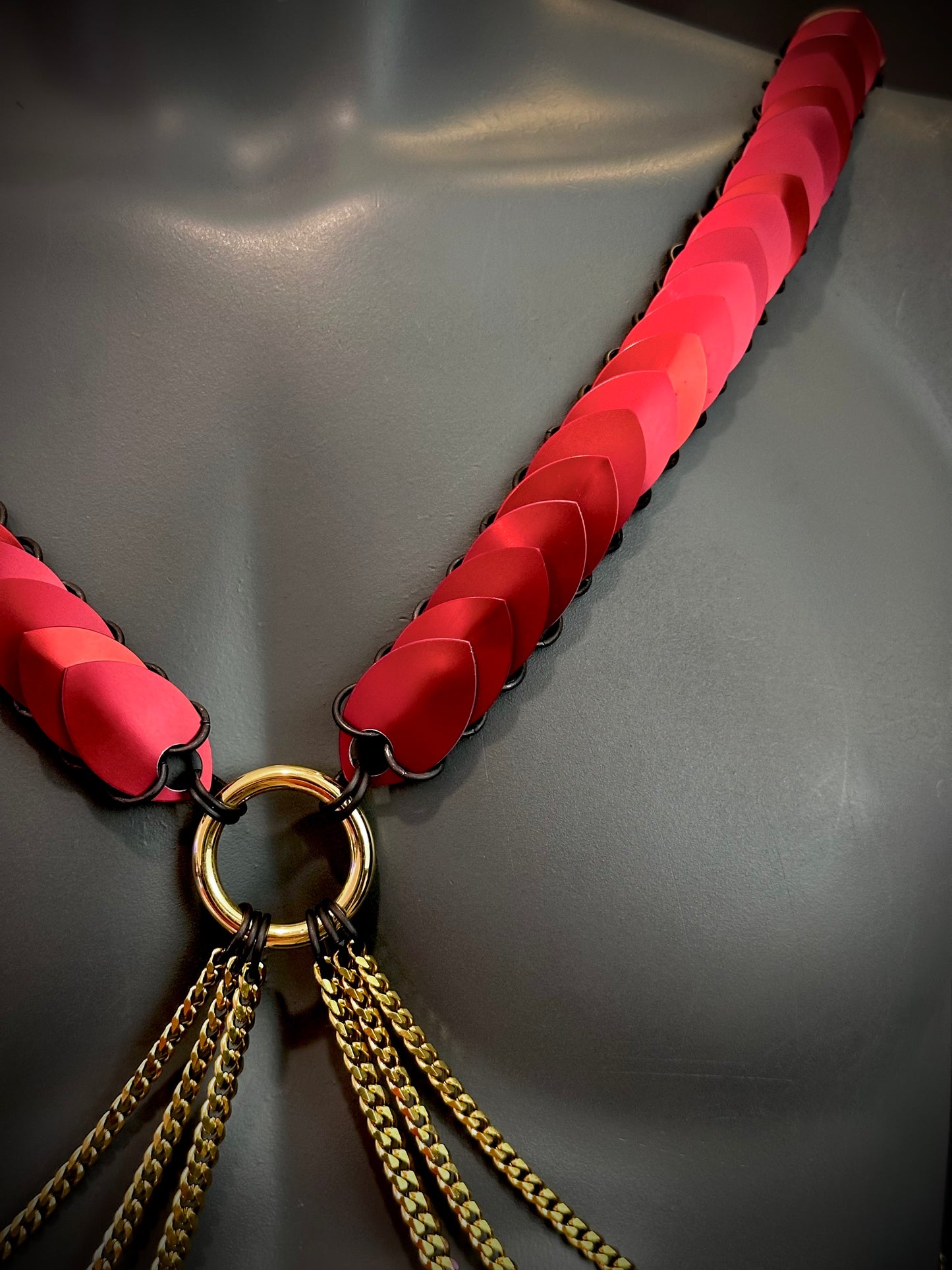 Armband Harness rot mit goldenen Ketten und glänzendem Ring, mutig und elegant