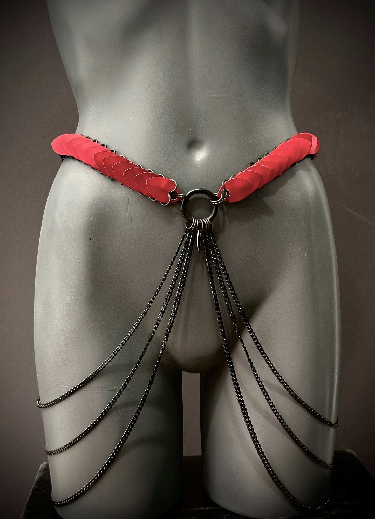 Ariv Harness Belt schwarz mit roten Akzenten und schwarzen Ketten, stilvoll und provokativ