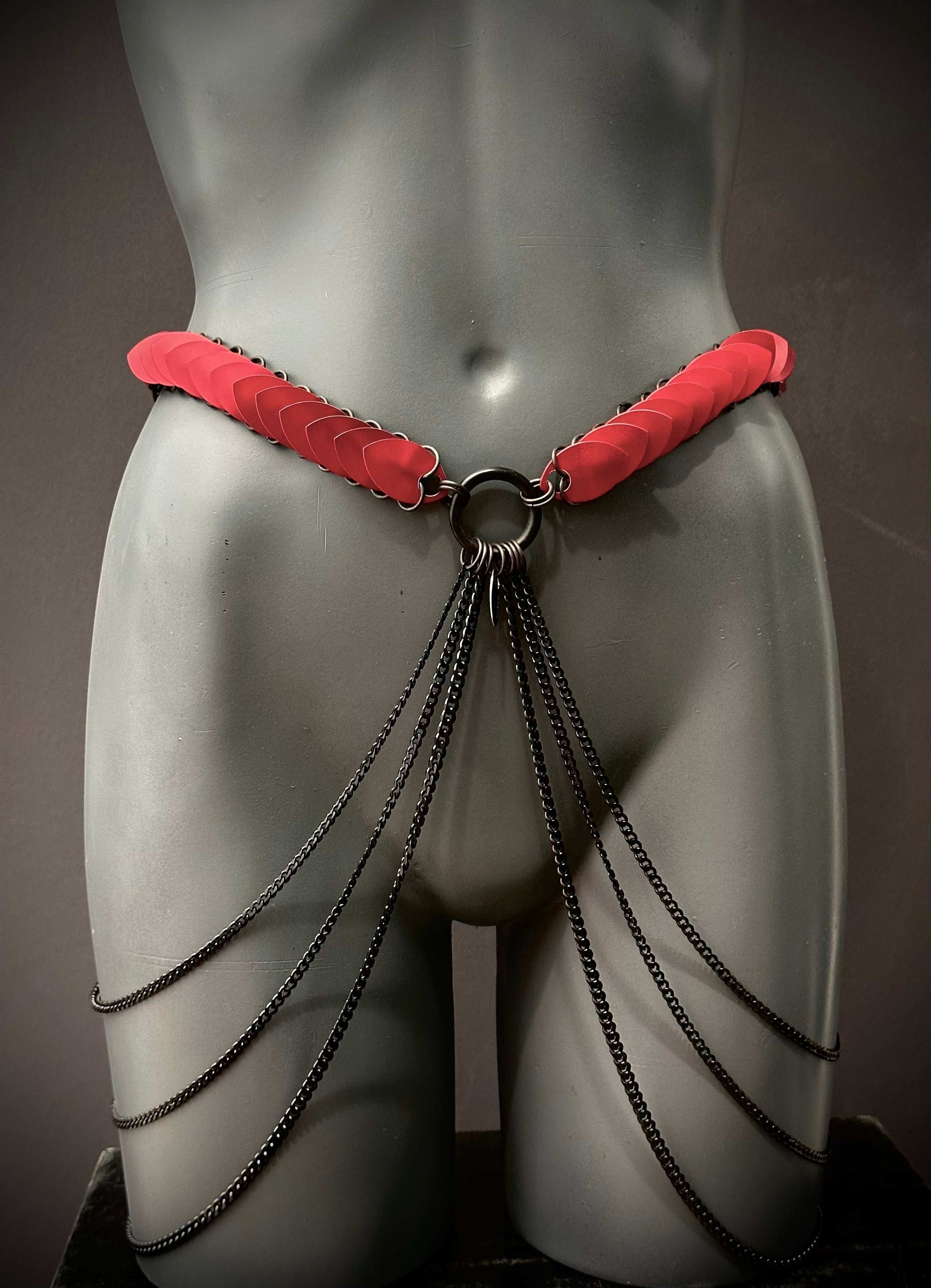 Ariv Harness Belt schwarz mit roten Akzenten und schwarzen Ketten, stilvoll und provokativ