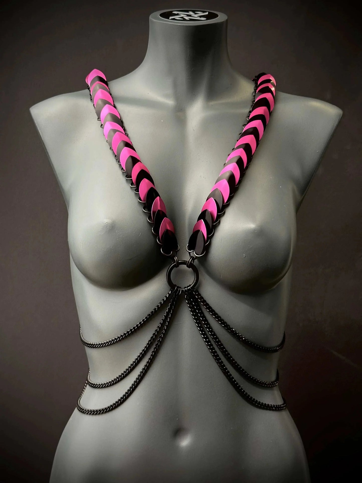 Armband Harness schwarz pink mit Ketten auf grauer Schaufensterpuppe, stylish und mutig