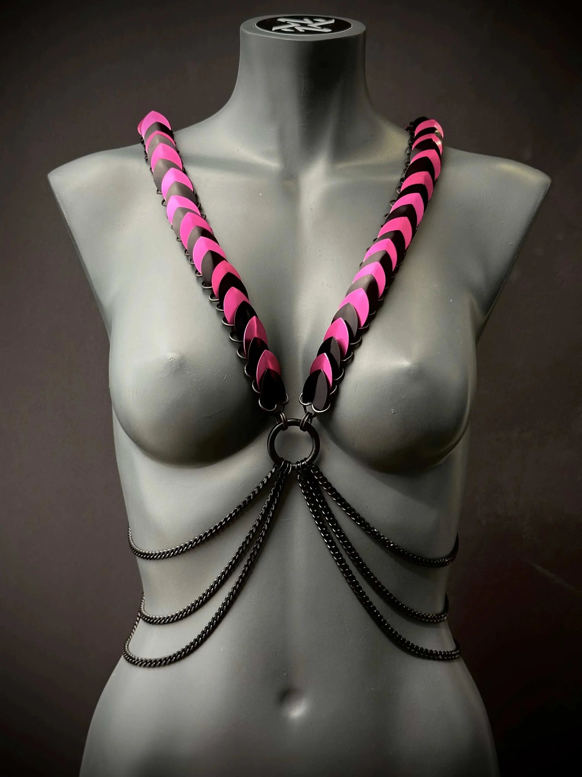 Armband Harness schwarz pink mit Ketten auf grauer Schaufensterpuppe, stylish und mutig