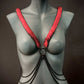 Armband Harness in Schwarz und Rot aus Ketten am grauen Schaufenster, kraftvoll und provokativ