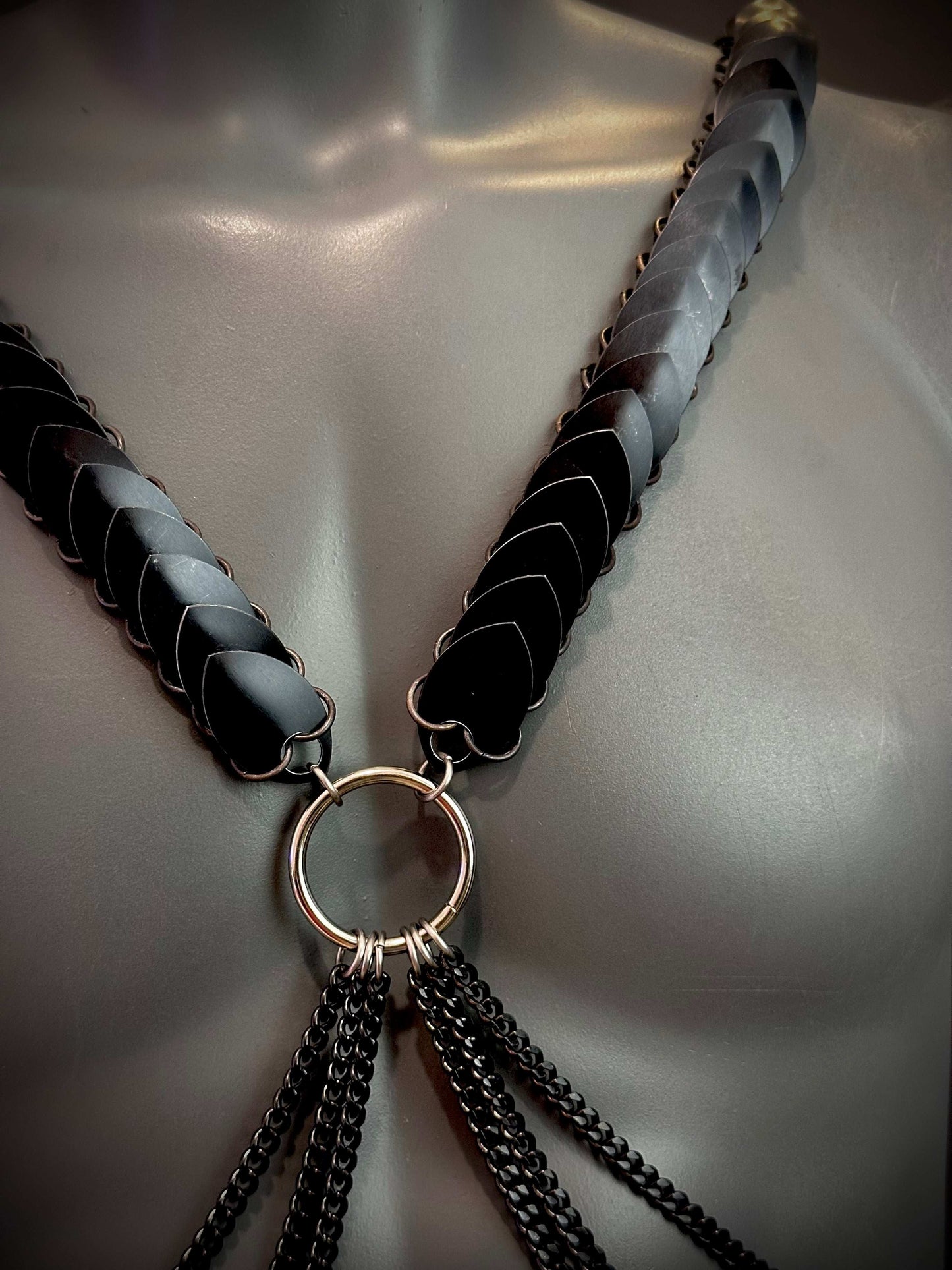 Schwarzer Ariv Harness mit Metallringen und Ketten, elegant und kraftvoll wirkend