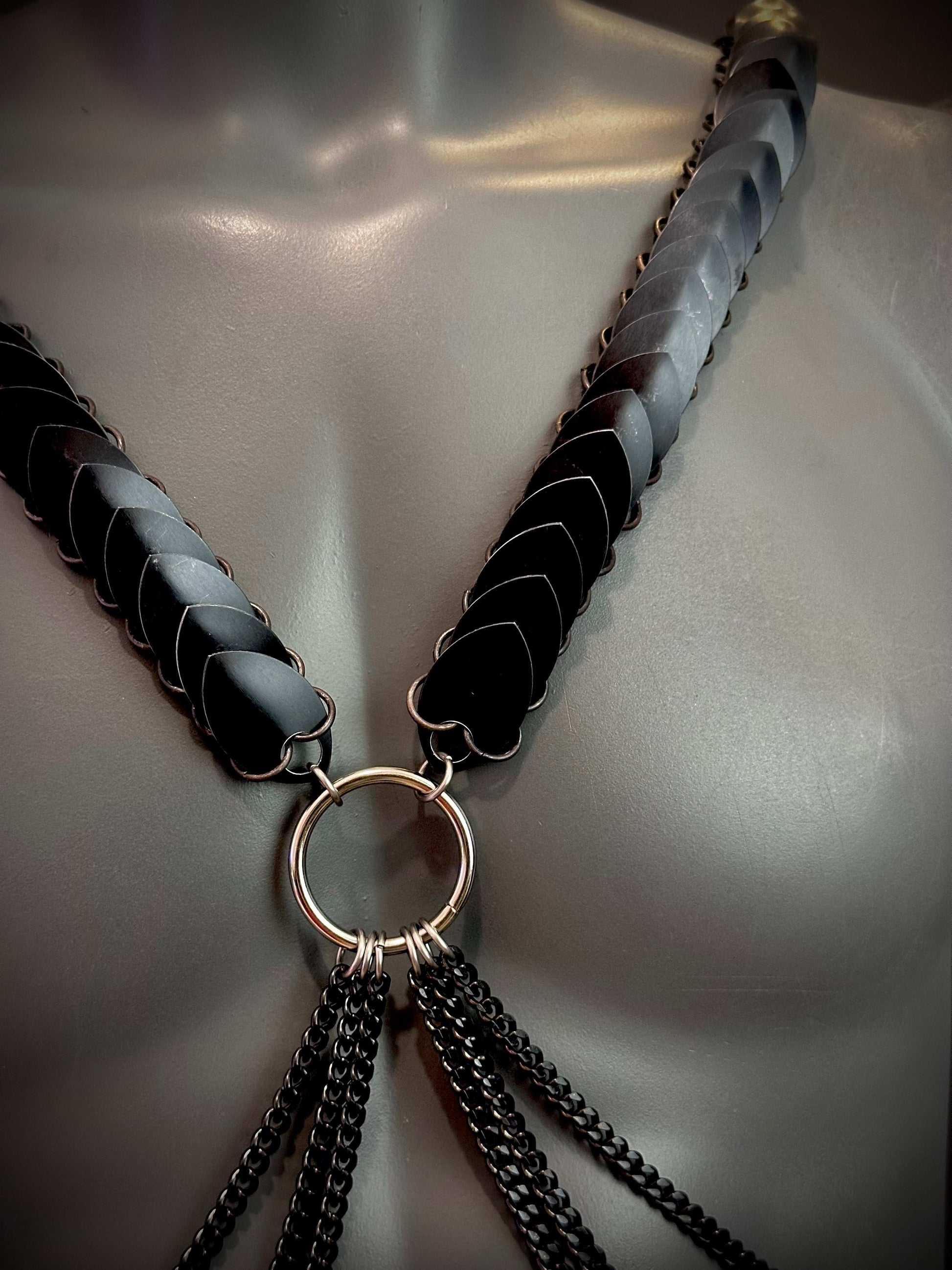 Schwarzer Ariv Harness mit Metallringen und Ketten, elegant und kraftvoll wirkend