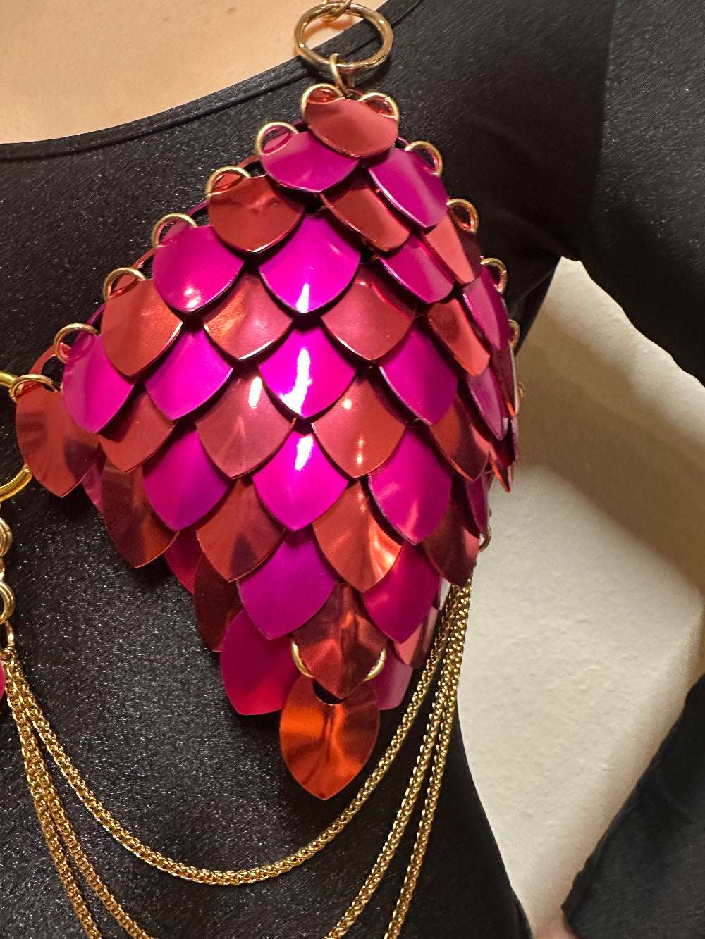 Bra aus dunkelroten und hot-pinkfarbenen Pailletten mit goldenen Ketten, auffällig und lebhaft