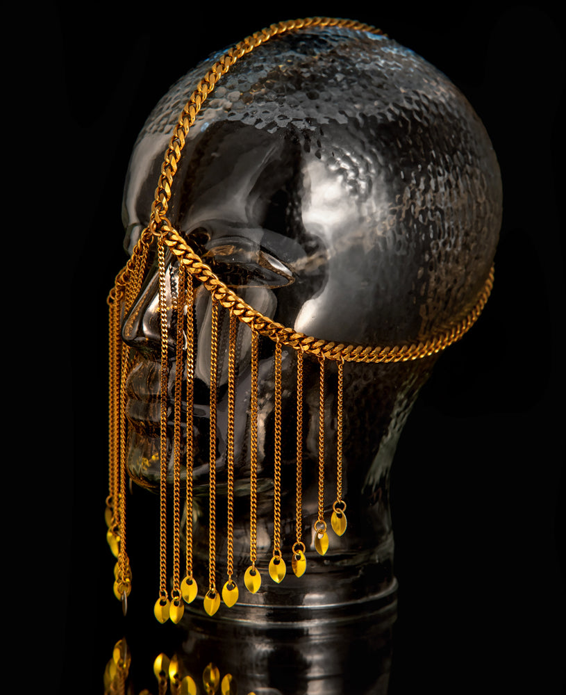 Goldene Facechain mit Kettenfransen an gehämmerter Glas-Kopfskulptur, eleganter Stil, mystische Ausstrahlung
