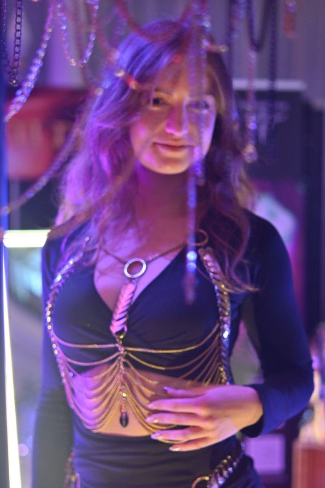 Kira steht zwischen den bodyketten in einen a genehmen Licht und trägt die 14k Gold Kette 