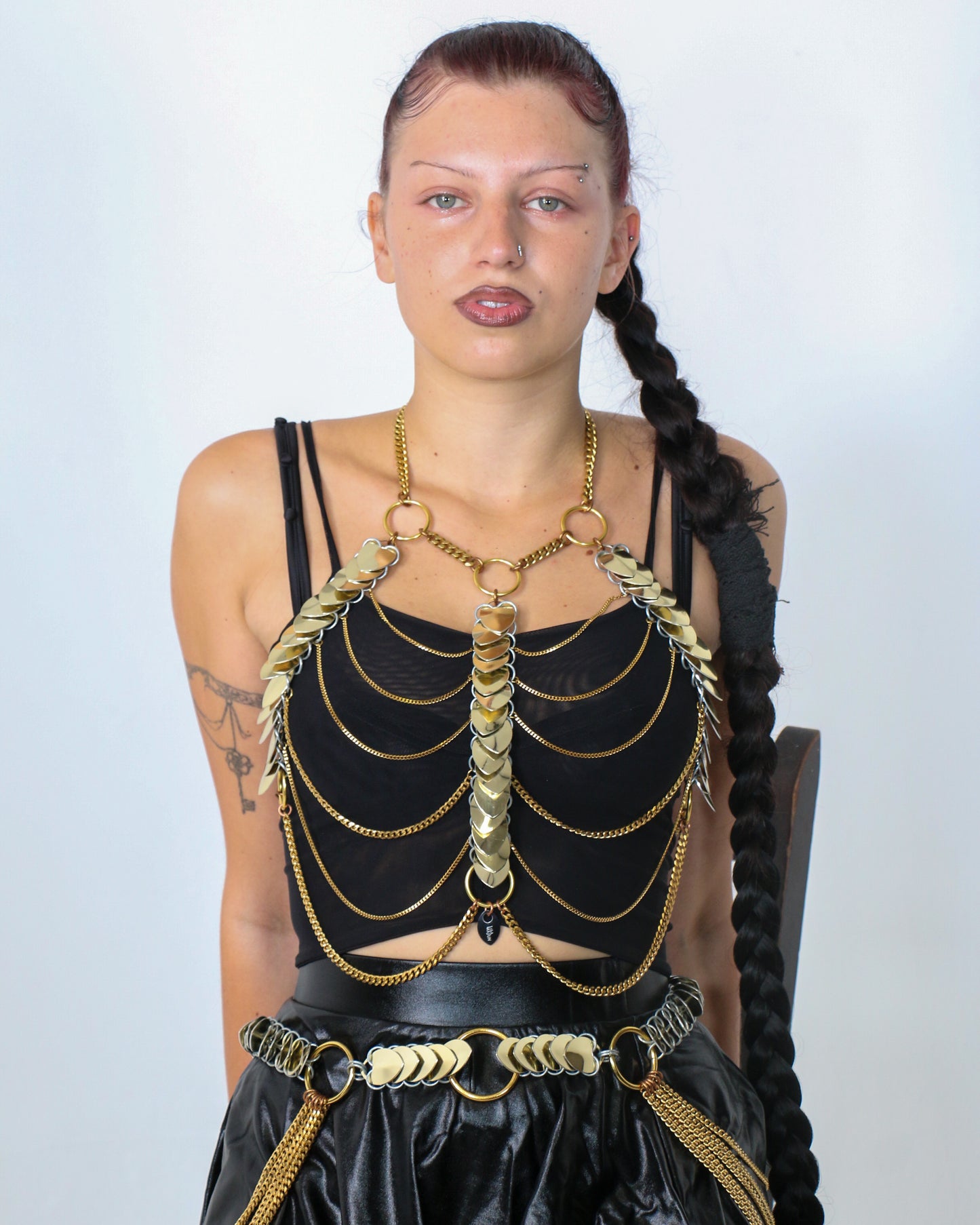 Leonie sitzt am Stuhl und passiert, sie hat eine Aphrodite Fire Kette an 