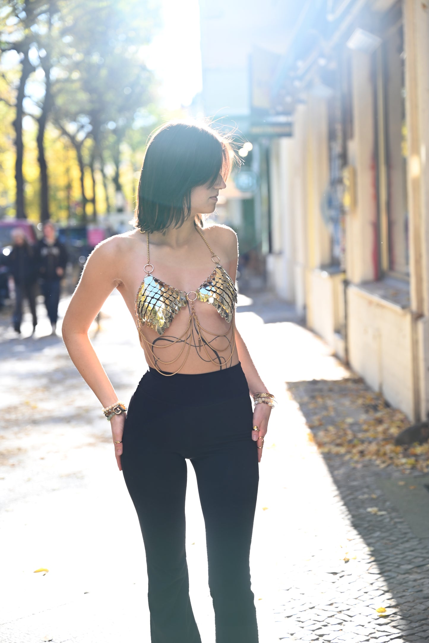 metal chain bra with gold scales and black high-waist pants streetwear fashion confident vibe