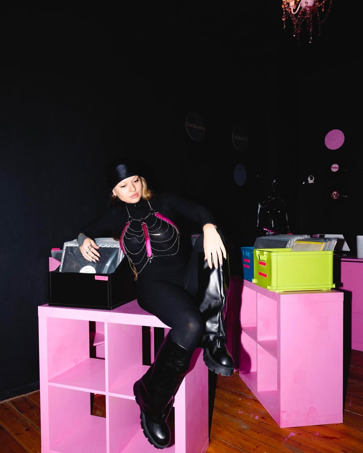 Girl siting on pink furniture with pink harness 