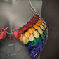 Metal scale mail bra in rainbow hues with silver chains, vibrant and bold, evoking confidence