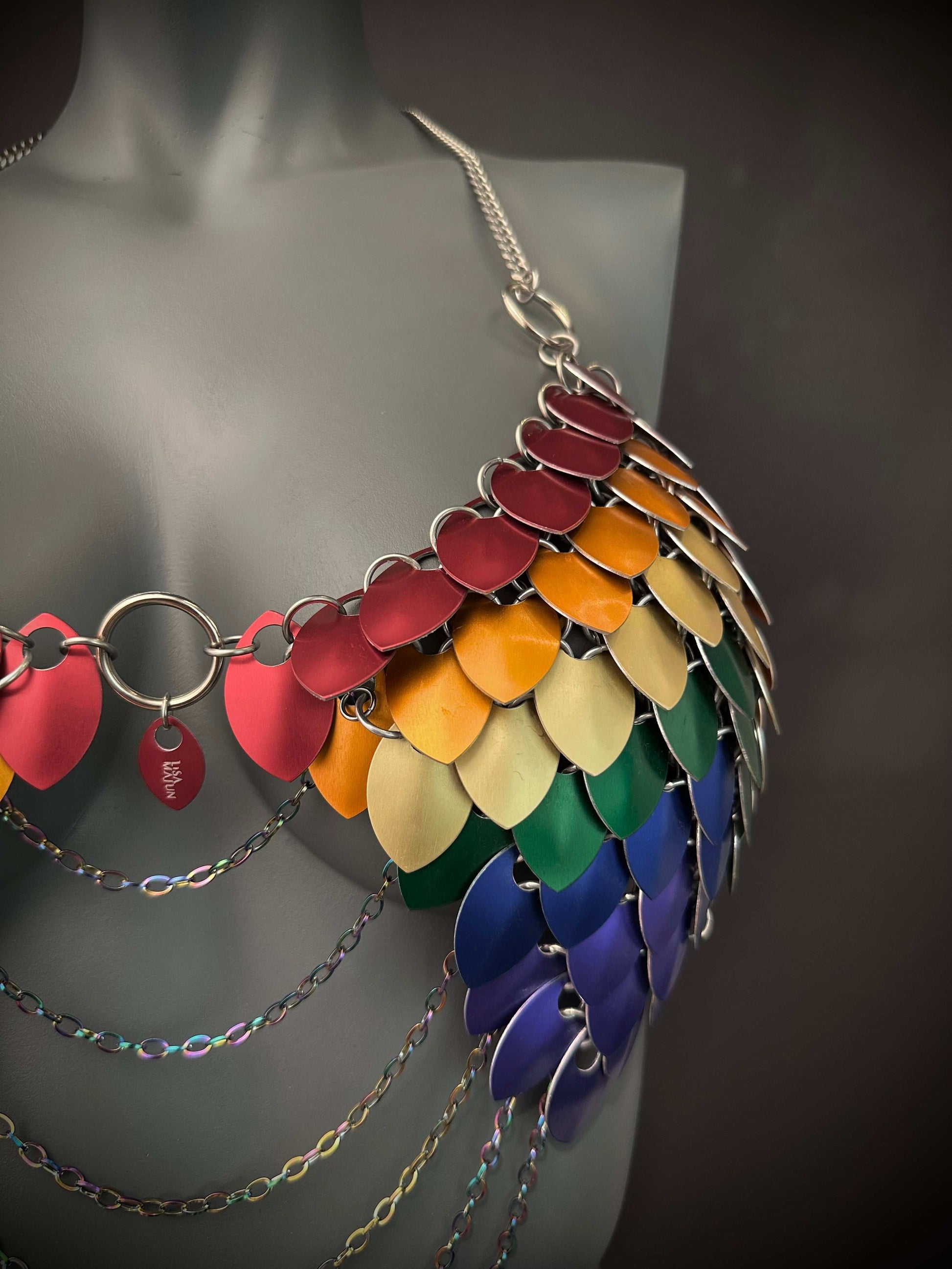 Metal scale mail bra in rainbow hues with silver chains, vibrant and bold, evoking confidence