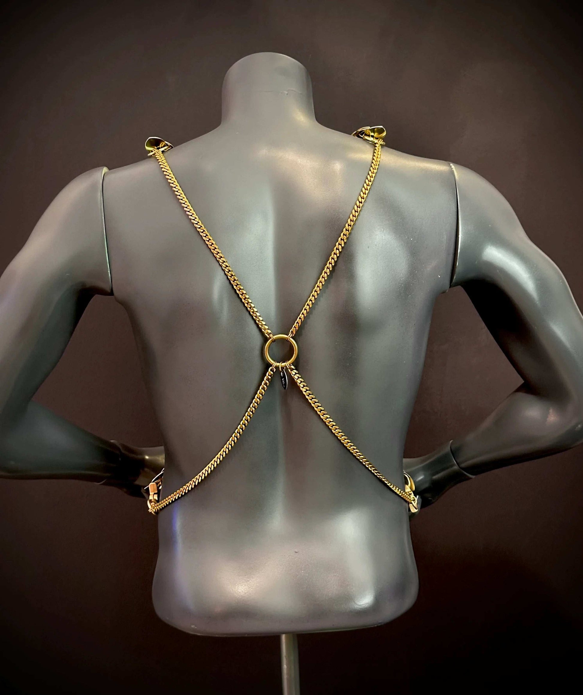 Goldfarbes Xenia Harness am Rückseite eines schwarzen Schaufensters, elegant und modern