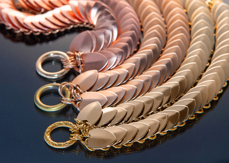 Metallic chain bracelets in rose gold, copper, and gold with sleek, modern style evoking elegance