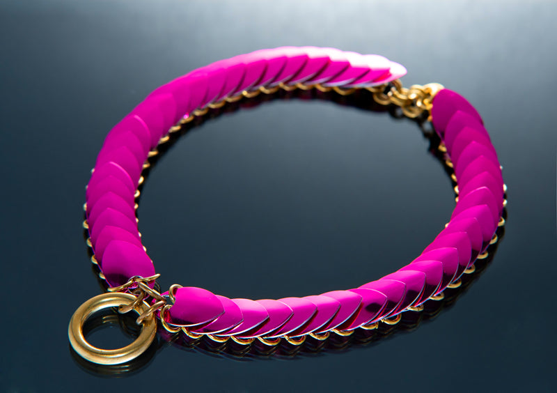 Pink Choker aus geflochtenem Material mit goldfarbenem Ring, modern und elegant wirkend