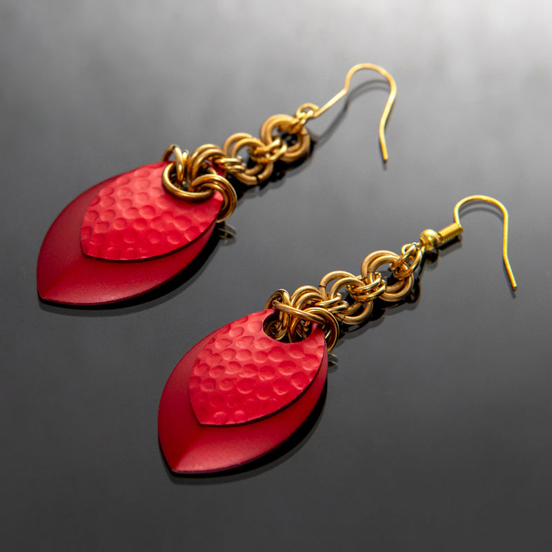 rote Ohrhänger, goldene Ringe, moderner Stil, elegant und ausdrucksstark