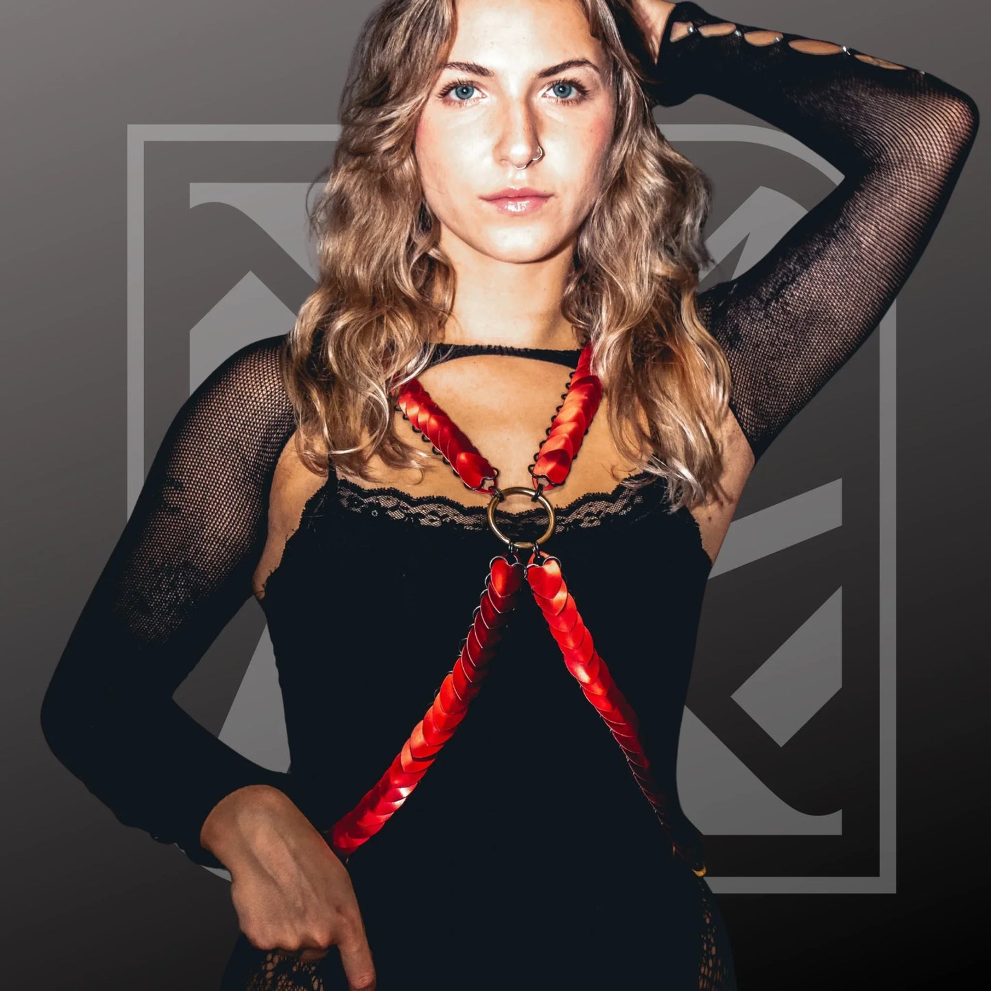 Frau trägt Scalemail-Bodyharness in Rot, Kettenstil, moderne Festival-Mode, selbstbewusster Ausdruck.